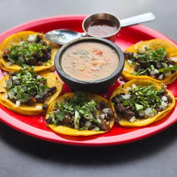 Five La Mex street tacos with meat, onions, and cilantro, served with two dipping sauces.